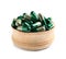 Wooden bowl with green spirulina capsules