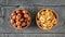 Wooden bowl with hazelnuts and wallnuts on a black rustic table. The view from the top