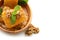 Wooden bowl with honeycomb, mint and nuts on white background