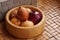 A wooden bowl made of bamboo wood filled with onions. Kitchen