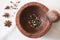 Wooden bowl with red white and black pepper with milling stick