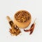 Wooden bowl and scoop full of crushed red cayenne pepper, dried chili flakes and seeds isolated on a white background. Homemade