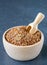 A wooden bowl and scoop with linseed