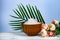 Wooden bowl with sea salt, rose and palm leaf