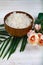 Wooden bowl with sea salt, rose and palm leaf