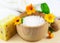 Wooden bowl with sea salt, soap, towels and marigolds