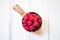 Wooden bowl with summer raspberries on white table