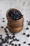 Wooden bowls full of dry black beans on aged wooden table closeup