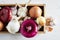 Wooden box with fresh garlic and onion on white background. Still life with raw vegetable. Concept of healthy food and nutrition.