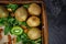 A wooden box with juicy kiwis in a mason jar on a dark gray background, top view. Kiwi on wooden tray. Copy space