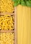 Wooden box with spaghetti and fusilli and macaroni with maccheroni and fresh basil
