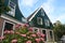 Wooden and brick house in northern Europe. In the foreground garden with hydrangea with pink flowers