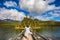 On the wooden bridge elderly woman performs yoga