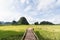 Wooden bridge going through rice field towards mountains of Tam Coc park in Ninh Binh, Vietnam