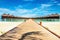 Wooden bridge leading to an exotic bungalow on the background of azure water, maldives