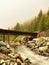 Wooden bridge over Alps rapids on quick mountain river in Alps