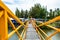 A wooden bridge over the canal The steel building painted yellow