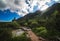 Wooden Bridge over Creek under Mountain Peaks