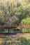 Wooden bridge over mirrored pond in the autumn park