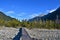 Wooden bridge over the river leading into the forest and high mountains.