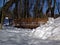 Wooden bridge in the Park across the stream in the snow