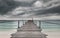 Wooden bridge and the sea with dark rain cloudy