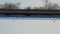 Wooden bridge on snowy frozen lake, aerial