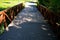 Wooden bridge with a stone foundation newly built for cyclists over a stream by the pond. wooden beams connected by screws and met