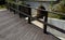 Wooden bridge with a stone foundation newly built for cyclists over a stream by the pond. wooden beams connected by screws and rop