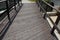 Wooden bridge with a stone foundation newly built for cyclists over a stream by the pond. wooden beams connected by screws and rop