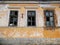 Wooden , broken windows on abandoned crumbling brick house