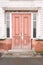 Wooden brown door. Old architecture. Light building wall