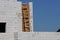 Wooden brown staircase by the gray brick wall of an unfinished house against the blue sky