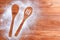 Wooden brown table dusted with flour. Silhouette two spoons in flour