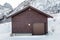 Wooden brown warehouse with roll door on snow
