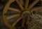 Wooden brown wheel with wide knitting needles close-up rustic background