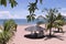 Wooden bungalow surrounded by palms and palm leaves on the beach with sand of light pink color near amazing lake Malawi or Nyasa