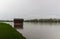 Wooden cabin, building on pond shore in rain moody weather. Long exposure, Czech landscape