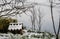 Wooden cabin covered with snow in a snowy area surrounded by bare trees