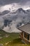 Wooden Cabin Log in High Alpine Mountains Dramatic Clouds and Storm Weather