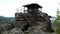 Wooden cabin on main peak of rock as view point, dark clouds in the sky. Summer early morning