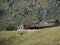 Wooden cabin perched on top of a hill at the foot of a big mountain in Wyoming