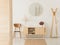 Wooden cabinet with flowers between stylish brown chair and wooden hanger