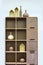 Wooden cabinet with shelves filled with decor, wooden vases and bottles. Wooden products, furniture and decor