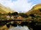 Wooden cabins reflecting on the water amongst the fjords, Urke, Norway