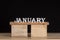 Wooden calendar months - January. Wooden letters on black background. Space for date