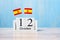 Wooden calendar of October 12th with miniature Spain flags. National Day of Spain and happy celebration concepts