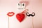 Wooden calendar and red heart with mustaches and lips paper prop on pink background