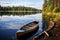 wooden canoe docked on the shore of a still lake