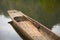 Wooden canoe with an oar on the calm lake water